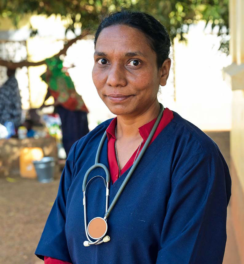 Schwester Bindu George trägt ein Stethoskop um den Hals und lächelt verhalten in die Kamera.