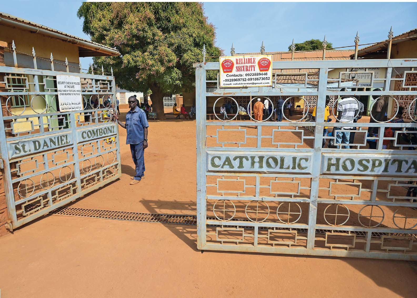 Ein Mann öffnet das Tor des St. Daniel Comboni Catholic Hospital.