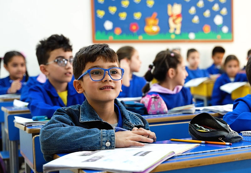 Ein Junge blickt von seinem Schreibheft auf