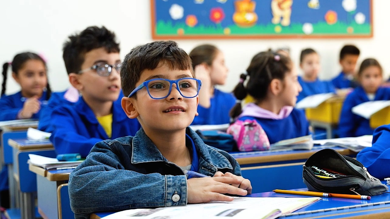 Ein Junge sitzt in seiner Klasse in Damaskus und schaut mit wachem Blick zur Tafel