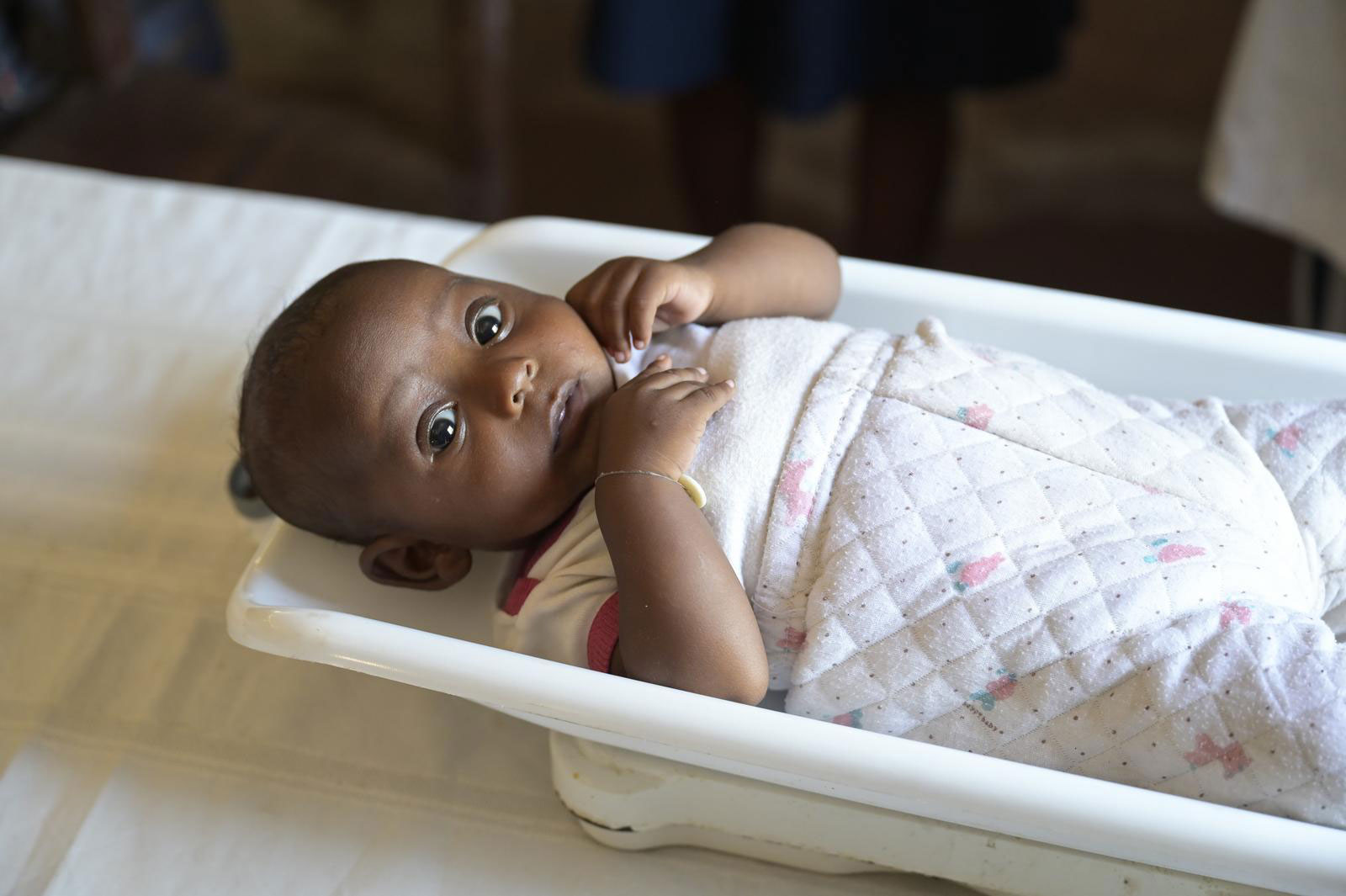 Ein Baby liegt in einer mobilen Krankenstation auf Madagaskar auf einer Waage