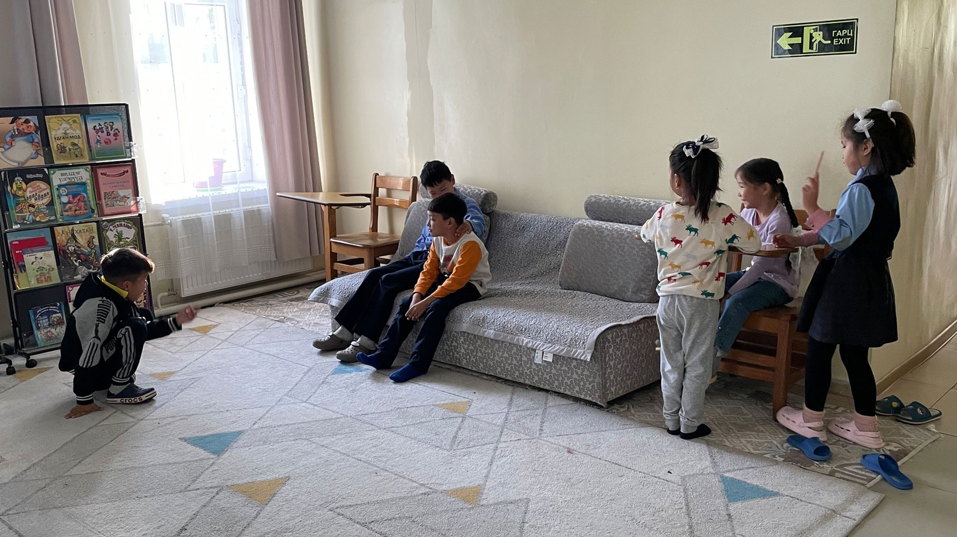 Junge Mädchen und Jungen sitzen in einem Aufenthaltsraum des Waisenhauses in Ulanbaatar