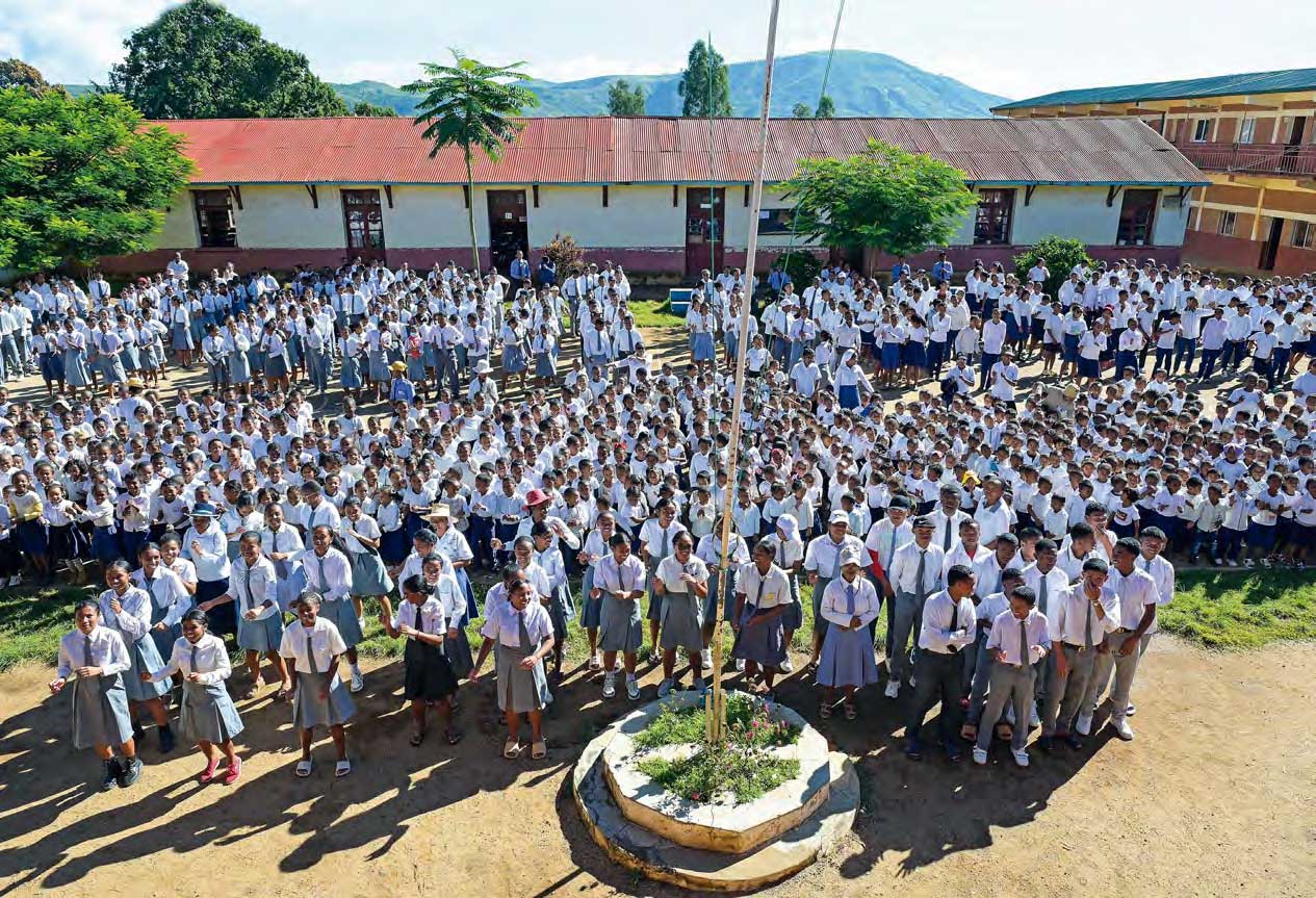 Hunderte Schülerinnen und Schüler in Schuluniform stehen im Innenhof einer Schule in Madagaskar.