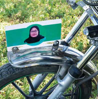 Auf dem Schutzblech eines Motorradvorderreifens ist das Porträt der Tansanischen Präsidentin zu sehen.