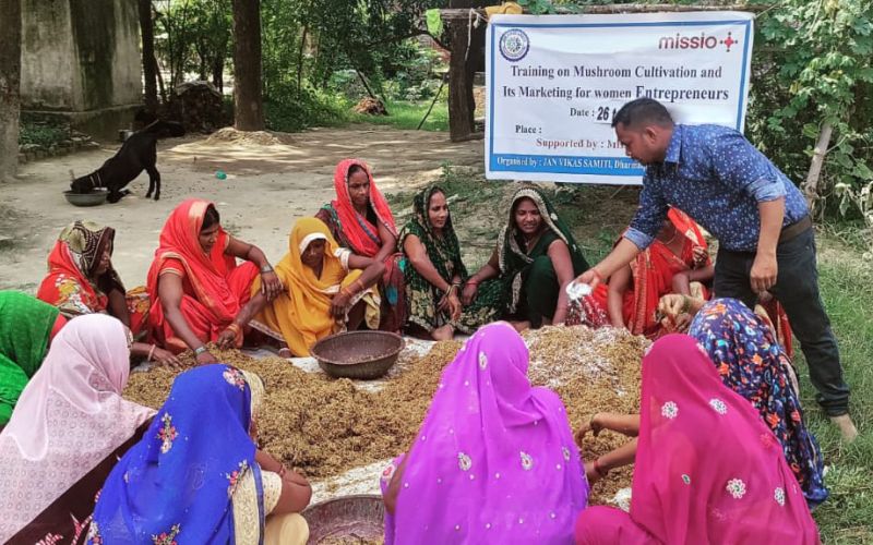 Frauen sitzen in Indien in einem Kreis auf dem Boden.