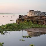 Ein verrosteter Panzer steht an einem Flussufer. Fotograf: Jörg Böthling