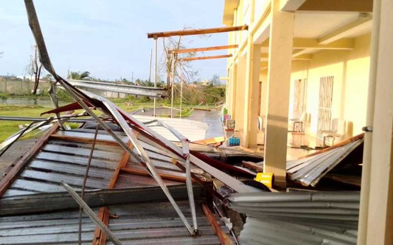 Das durch einen Zyklon zerstörte Frauenhaus von Don Bosco in Madagaskar: Das Dach aus Holz und Wellblech liegt zerdrückt und verbogen auf dem Boden neben dem Gebäude.
