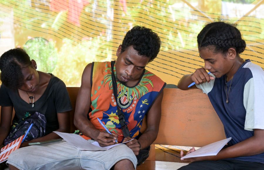 Junge Männer sitzen in einem Workshop zur Umweltbildung auf Papua-Neuguinea