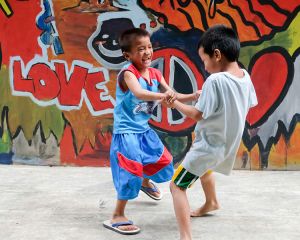 Zwei Jungen spielen im Kuya Center in Manila vor einer Grafifti-Wand.