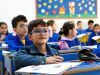 Bild 1: Junge im Klassenzimmer blickt von seinem Heft auf
