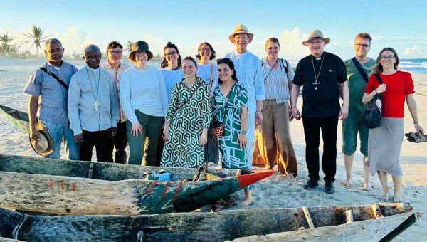 Gruppenfoto der missio-Delegation auf einem Strand in Madagaskar. Im Vordergrund mehrere einfache Boote aus Holz.