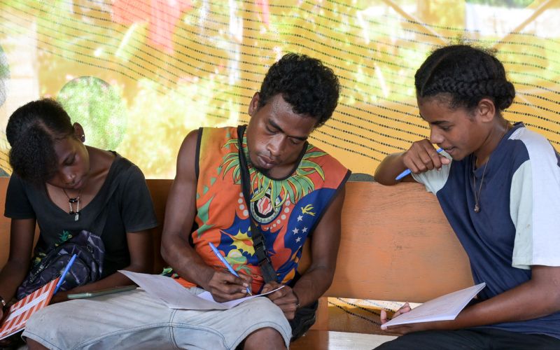 Junge Männer sitzen in einem Workshop zur Umweltbildung auf Papua-Neuguinea