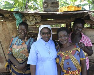 Gruppenfoto von vier Frauen: Die zweite von links ist Schwester Veronica, die anderen sind Bewohnerinnen eines Slums in Uganda.
