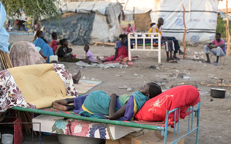 Ein geflüchtetes Kind aus dem Sudan liegt auf einem Bettgestell im Flüchtlingszentrum in Renk