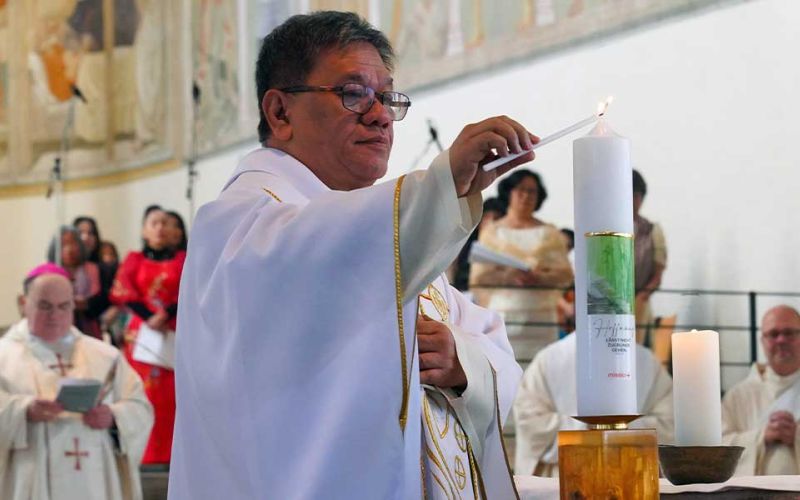 Zu sehen ist der philippinische Priester und Menschenrechtsaktivist Christian "Toots" Buenafe, der beim Gottesdienst zum Sonntag der Weltmission in der Stadtpfarrkirche St. Josef in Memmingen die Kerze zum Weltmissionsmonat entzündet.