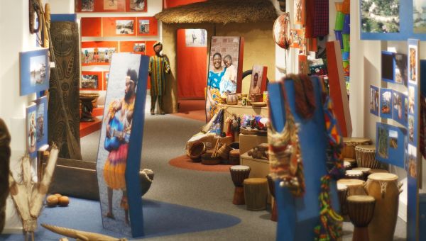 missio-Ausstellungsraum mit großen Foto-Aufstellern und Trommeln.