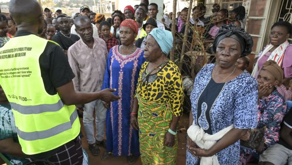 Ein Mann vom Jesuit Refugee Service in Kampala erklärt neu angekommenen Flüchtlingen, wie sie Hilfe erhalten. Jörg Böthling/missio München