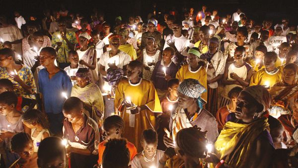 Osternacht in Äthiopien: Menschen in bunten Gewändern halten Kerzen in den Händen - farbenfroh werden sie erleuchtet.