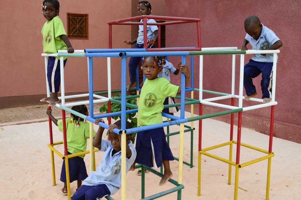 Das Bild zeigt ein Spielgerüst mit sieben darauf turnenden Kindern.