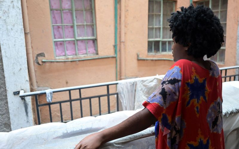 Eine Überlebende von Menschenhandel steht auf einem Balkon in Kenia. Sie ist nur von hinten zu sehen.