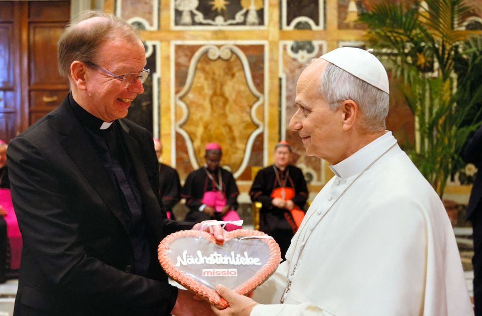 Monsignore Huber überreicht Papst Leo XIV. ein Wiesn-Herz mit der Aufschrift "Nächstenliebe"