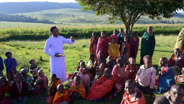 Ein Katechist feiert mit Massai einen Gottesdienst im Freien in Tansania.