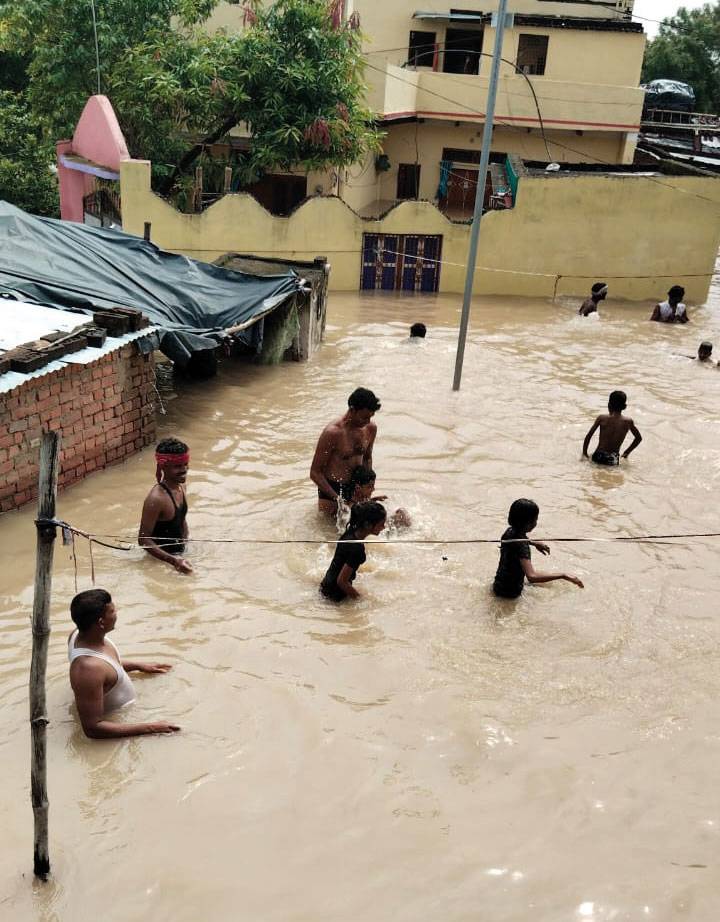 Erste Eindrücke nach der Flut: Menschen stehen bis zur Hüfte unter Wasser in der Straße