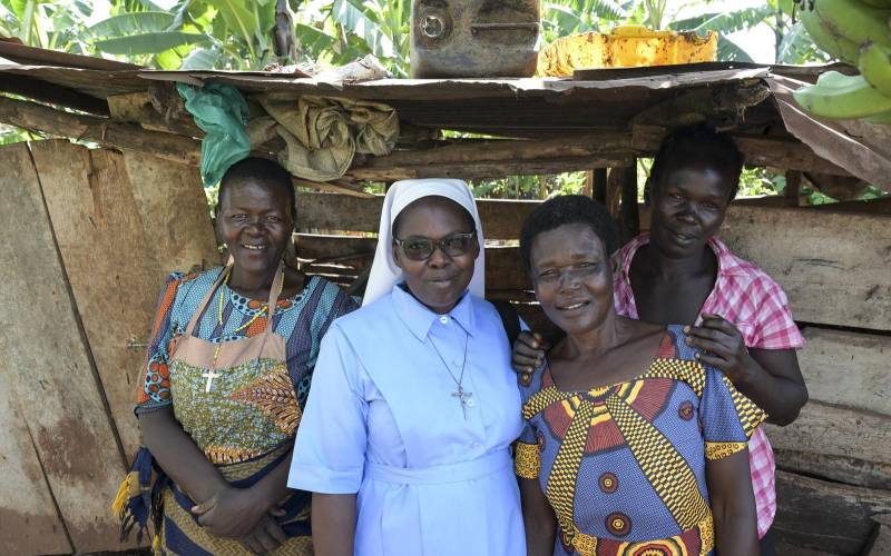 Gruppenfoto von vier Frauen: Die zweite von links ist Schwester Veronica, die anderen sind Bewohnerinnen des eines Slums in Uganda.