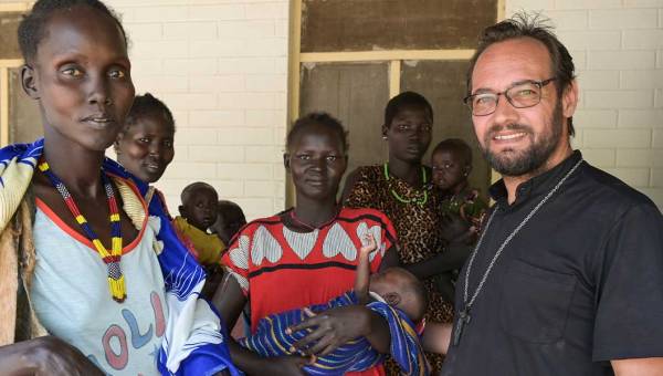 Zu sehen ist eine Gruppe von Menschen aus dem Südsudan, rechts vorne im Bild steht missio-Projektpartner Christian Carlassare, Bischof von Bentiu.