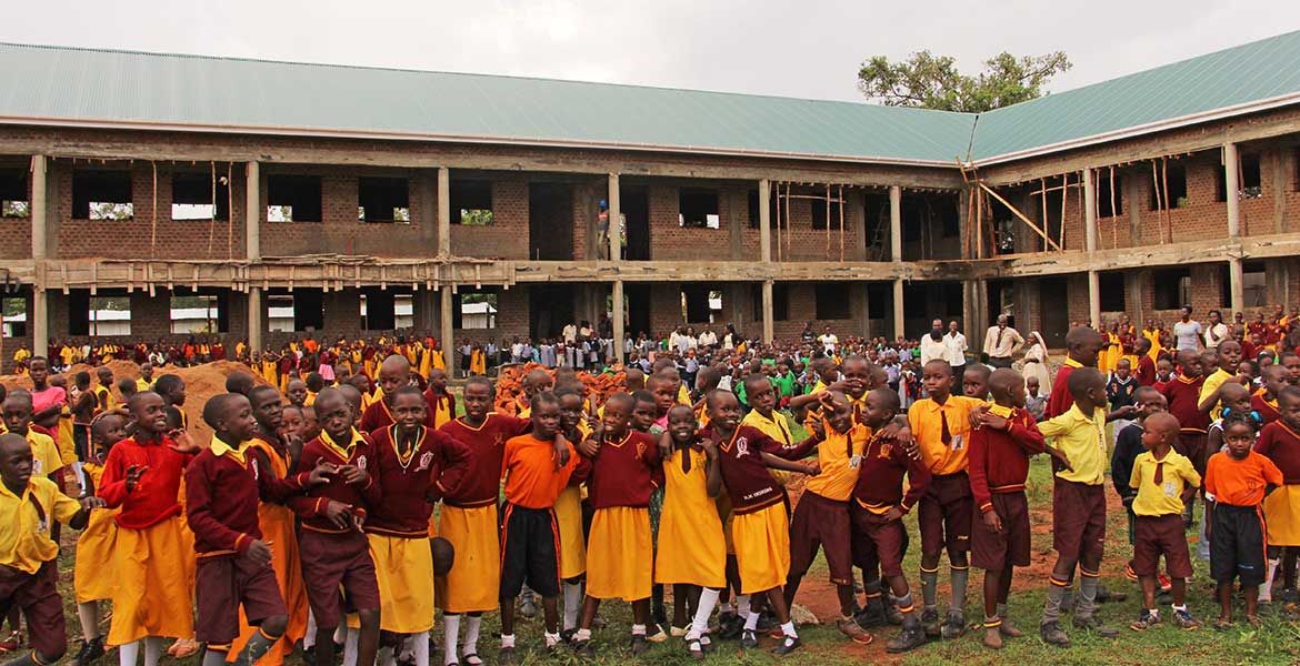 Schüler stehen vor dem Erweiterungsbau der Mother Kevin Junior School in Pallisa