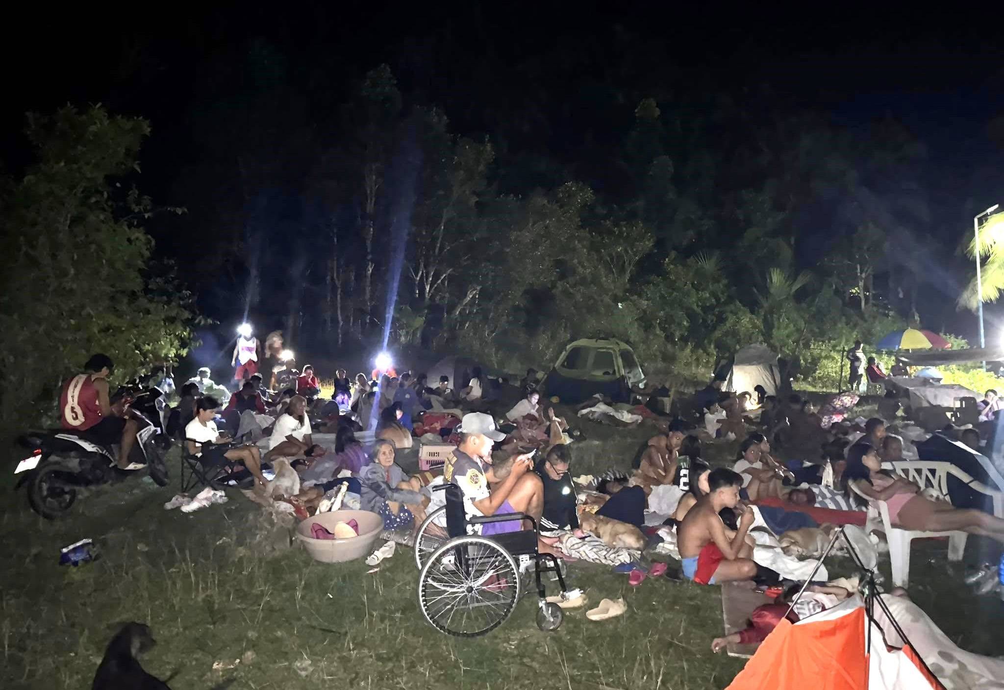 Nach dem Erdbeben auf den Philippinen sitzen Menschen ohne Obdach mit ihren Habseligkeiten auf einer Wiese. Im Einzugsgebiet von San Remegio sind noch viele obdachlos. Foto: Projektpartner missio München
