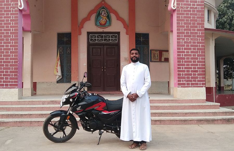 Priester mit Motorrad in Indien