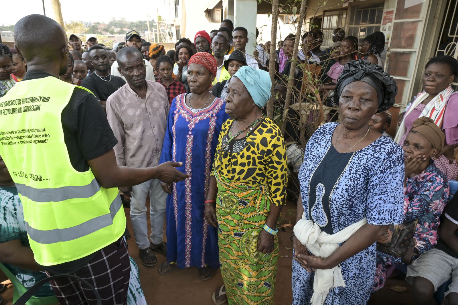 Ein Mann vom Jesuit Refugee Service in Kampala erklärt neu angekommenen Flüchtlingen, wie sie Hilfe erhalten