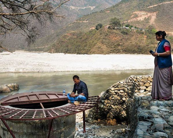 Menschen aus dem Dorf Koshidekha in Nepal stehen unten am Fluss. Ihr Wasserproblem ist gelöst.