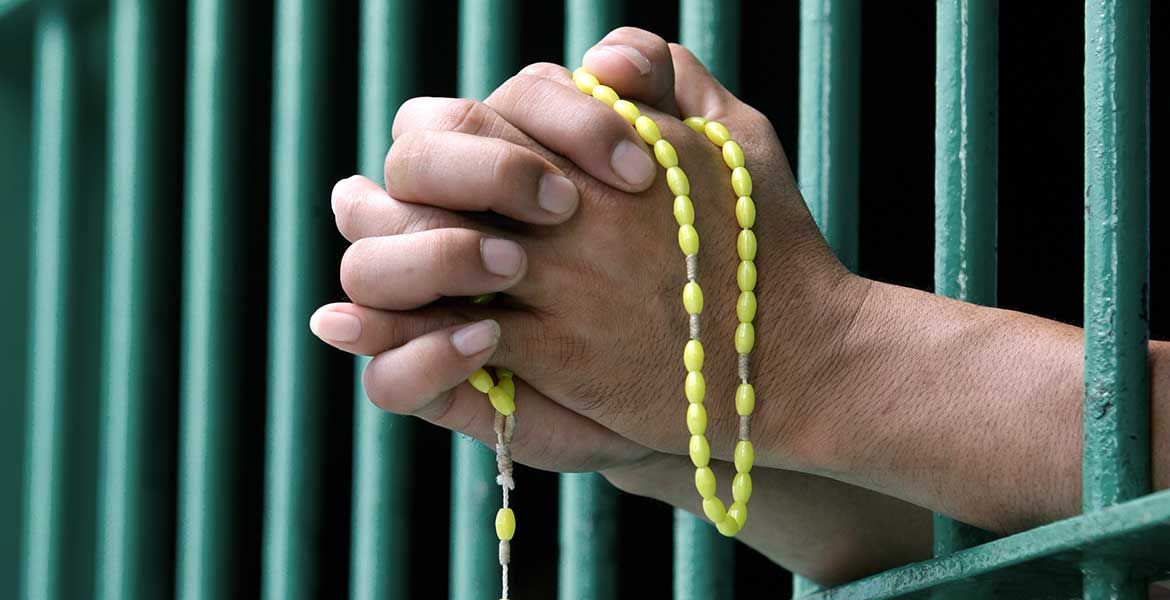Ein Gefängnisinsasse betet mit Rosenkranz