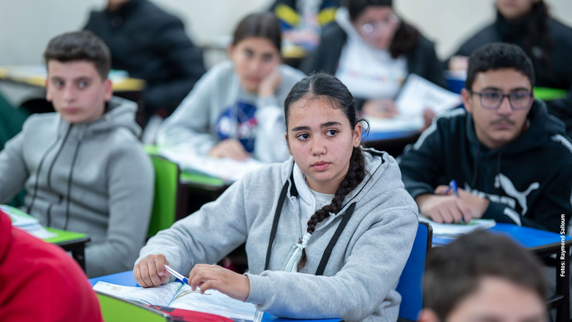 Kinder in der Schule, im Mittelpunkt des Bildes ist ein Mädchen zu sehen