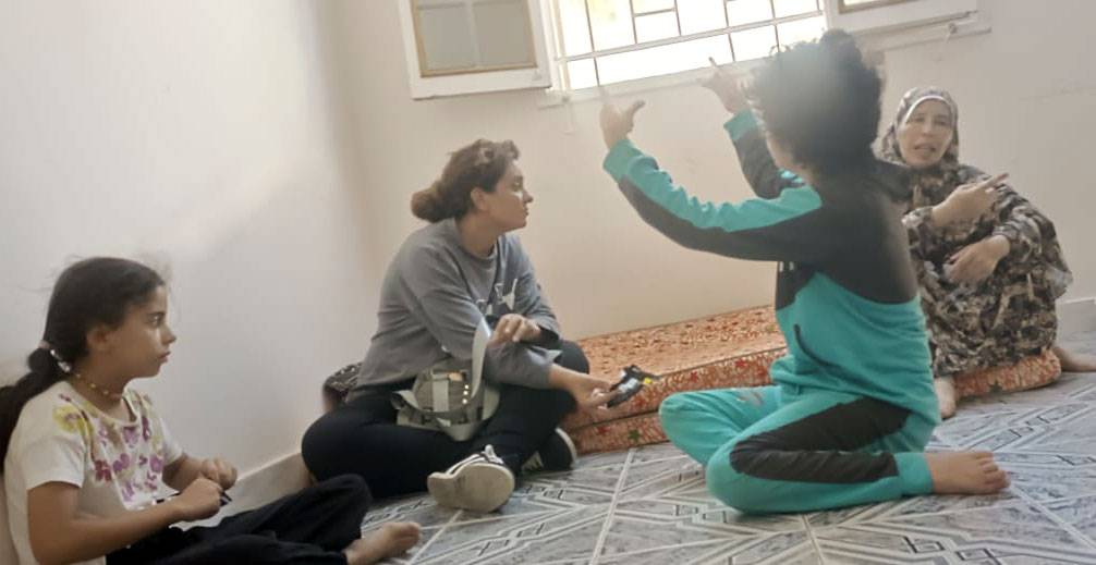 Zwei Mütter und zwei Kinder aus Gaza sitzen in einer Unterkunft für Geflüchtete auf dem Boden