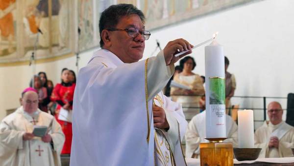 Zu sehen ist der philippinische Priester und Menschenrechtsaktivist Christian "Toots" Buenafe, der beim Gottesdienst zum Sonntag der Weltmission in der Stadtpfarrkirche St. Josef in Memmingen die Kerze zum Weltmissionsmonat entzündet.