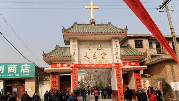 Eine Kirche in China mit goldenem Kreuz auf dem traditionellen Dach.