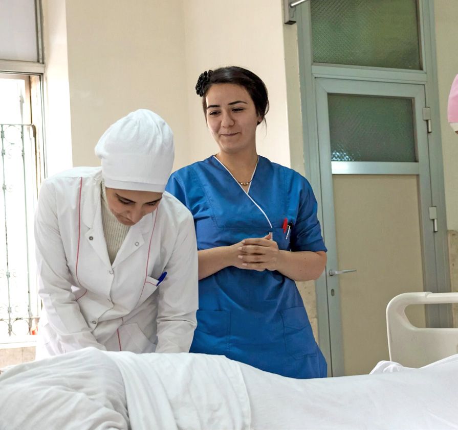 Zwei Schwestern am Bett eines Patienten